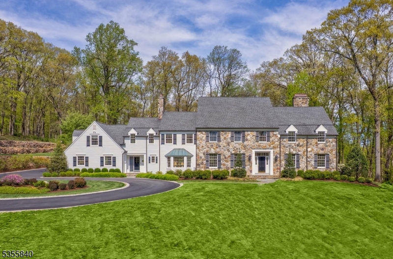 An exceptional Bernardsville Mountain residence offers spacious living and effortless entertaining, both indoors and out. Set atop a gentle hill amid 5.3 acres of beautiful landscaping, this five-bedroom home invites refined living in one of this historic former mountain colony's most desirable locations. Surrounded by established landscapes and stone walls, the setting is completely private. Its sun-drenched interior is spacious and thoughtfully designed, with well-appointed rooms and a gracious flow. At the heart of the home is a stunning designer kitchen featuring two large islands, custom cabinetry and top-of-the-line appliances including a La Cornue French range. A bright sunroom and elegant living room both open to a bluestone patio with an outdoor fireplace and pool for easy indoor/outdoor entertaining. Also on the first floor is a home office with a gas fireplace and charming bar. On the second floor, an expansive primary suite includes a sitting area with a cozy gas fireplace, two roomy walk-in closets and a spa-like bath with a soaking tub and ample natural light. Four additional bedrooms each have updated baths and custom California Closets. The finished basement provides additional living spaces in a media room, oversized recreation room, wine cellar and a full bath. Situated just minutes from downtown Bernardsville's shops, restaurants and Midtown Direct trains, this distinctive residence perfectly balances peaceful country living and convenient access to town.