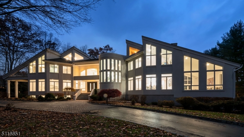 Welcome to this fully renovated incredible lakefront luxury estate nestled in the sought after Smoke Rise gated community in Kinnelon. No expense was spared on this 5 bedroom, 5 full and 1 half bath home with the highest quality finishes and an open layout throughout. First floor features a sunken great room with fireplace and floor-to-ceiling windows, family room with fireplace, bedroom suite, formal dining room, additional family/sitting room and a laundry room. The Chef's gourmet custom eat-in kitchen is complete with quartz countertops, high-end appliances, separate breakfast area and access to the large deck overlooking the private and lush backyard with Gunite pool. The second floor features a large master suite with luxurious master bath, walk-in closet, fireplace and two private terraces. Three additional bedrooms with walk-in closets and 2 full baths complete this level. The lower level is perfect for entertaining with a granite countertop wet bar, large recreation areas, fitness room, storage and full bath. Also featuring a 5 car garage, private loft area, generator, porcelain flooring and high-efficiency electric heat pumps.
