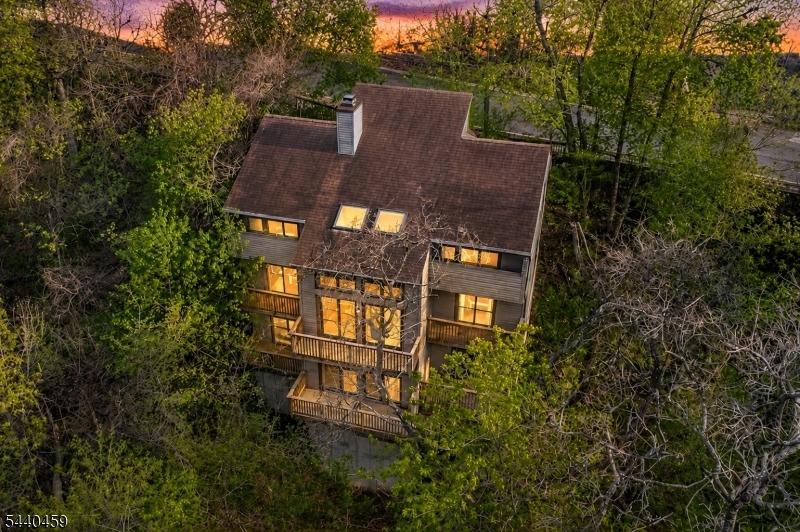 Walk to restaurants, shops, galleries, the D & R Canal path, Shad Festival and everything else that this vibrant river-front town of Lambertville offers, while enjoying the peace and quietude in your own private wooded oasis. This spacious 4BR, 3 BA custom home offers a flexible floor plan with a full BA & adjoining BR (also makes a great home office) on the entry level along with a generously sized Foyer/Sitting Room, Formal Dining Room and sunny Kitchen updated with granite counters, stainless steel appliances and tiled backsplash. Be one with nature as you enjoy tree-top views from the stunning 2-story Great Room with wall of glass doors and clearstory windows above. There's also a spacious FR on the lower level which includes an adjoining sitting room and sauna! Private decks on every level are an added bonus. Perfect for art collectors, this home offers the ideal backdrop for displaying expansive artwork and includes generous built-in bookcases & open shelving. Additional updates include newer roof (2011), new hot water heater (2023), newer flooring & renovated MBA with frameless glass shower door, granite-topped vessel sink vanity. Just 3 blocks from the NYC bus stop, this spectacular home offers the best of all worlds as the perfect year-round retreat while also enjoying all of the benefits of living in "NJ's Best Small Town"