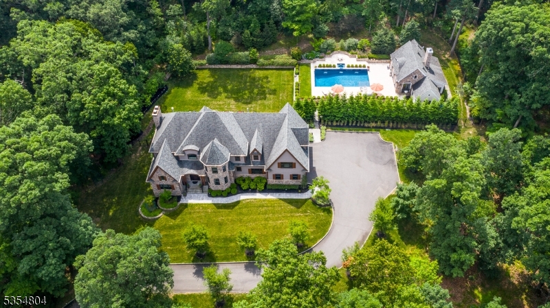 This elegant French country estate, nestled in the scenic Watchung Mountains, presents an exceptional opportunity to establish lasting roots in a welcoming community. Boasting 6 bedrooms and 4.5 baths, this home seamlessly blends sophisticated design with a warm and inviting atmosphere.  A separate guest house - featuring an additional bedroom, catering kitchen and 2 baths - overlooks a sparkling 20'x40' saltwater pool and spa, creating the perfect space for visiting family and friends and summertime entertainment.Meandering bluestone and gravel walkways invite exploration of the expansive 3.06-acre property, leading to beautiful travertine and bluestone patios that become natural extensions of your living space for outdoor gatherings. The expertly designed landscaping provides a breathtaking seasonal display, with flowering trees, bushes, and a vibrant perennial garden creating a picturesque backdrop from spring to fall.This private oasis offers a rare combination of elegance, comfort, and natural beauty an exquisite home where memories are waiting to be made. Interior photos will be available in June.