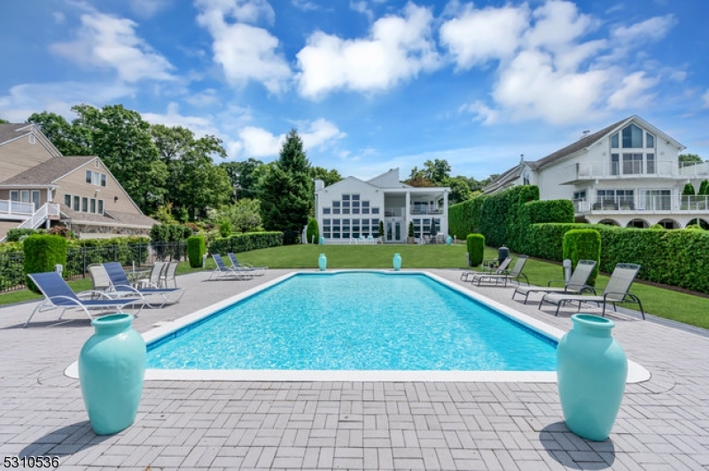 This stunning 2 story luxury lakefront offers 87 ft of pristine waterfront, combining exquisite custom-built design with premium details throughout. The property features an open floor plan that ensures a seamless flow between living spaces, further enhanced by a breathtaking two-story wall of windows that provide a scenic wooded shoreline. With western exposure, you can enjoy spectacular sunset views over the 40x20 in-ground pool and patio, all set against a backdrop of manicured, level landscaping. Designed with entertainment in mind, this home offers the flexibility of 1st floor living, making it both elegant and practical. The primary bedroom suite is a true retreat, featuring a dual-sided gas fireplace that can be enjoyed from both the jetted tub and the bedroom. The suite also includes a walk-out covered balcony with remote-controlled, all-season screens, offering a peaceful space to relax and take in the views. A spacious open loft provides breathtaking views of the lake for casual entertaining. Additionally, residents can join the private Lake Forest Yacht Club with access to a beach club, clubhouse, tennis courts, and a playground. The desirable neighborhood offers a friendly commuter location just moments away from shops and restaurants. Situated on New Jersey's largest lake, it offers four seasons of waterfront activities in a recreational paradise, with close proximity to hiking, biking, golf, and a ski resort. Create lasting memories and vacation where you live!