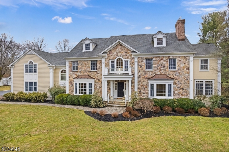 Custom colonial featuring a private yard on 2 acres. Home has impressive two-story foyer, custom millwork throughout, plantation shutters, open floorplan, HW floors and abundant light. First floor boasts an amazing family room with expansive windows and stone fireplace that opens to the kitchen.  The kitchen has granite countertops, professional SS appliances, butlers pantry, & doors leading to the backyard.  First floor also includes the office with custom millwork next to a full bathroom and wet bar, dining room, living room and additional powder room and back staircase. Impressive finished lower level. The backyard is an oasis for relaxation and entertainment with built-in gas grill, granite countertops, outdoor fridge, stone fireplace, stone sitting area on an expansive patio and professional landscaping.  Basking Ridge schools and Far Hills mailing address.