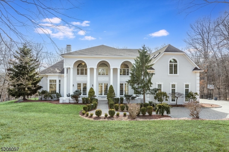 Nestled in one of Morris Countys most desirable towns, this Estate offers an upscale lifestyle on a quiet cul de sac amid an oasis of peace and privacy. Stunning, custom colonial on nearly 2.5 acres. A striking 2-story foyer announces the home's modern elegance. The entry is flanked by a spacious dining & living room w/WB fireplace & wet bar. The hub of the home is the family room w/cathedral ceiling & WB fireplace opens to the large kitchen with oversized center island. The library or study showcase fine craftsmanship & mill work. First floor bedroom suite & two powder rooms on either end of home. Great space & floorplan for entertaining guests. Upstairs you'll find an indulgent primary suite & 3 additional bdrms. Each with their own en-suite bath & walk-in closet. Large bonus room works as a rec room, playroom or office. Several options to work from home! Full, finished, walkout basement- Media room, exercise area, kitchenette, full bath & sauna. Plenty of storage. 3 Car Garage. Large windows throughout provide a beautiful ambience, tons of natural light, stunning views from every corner including panoramic views of both the Sunrise & Sunset. The 1500 sqft deck eases the transition from living indoors & out. In-ground pool, sweeping side yard & fenced in area! Come experience tranquility, luxury & privacy right in your own backyard w/all the conveniences of NYC mass transit, easy access to major hwys, shopping & dining. TOP schools!