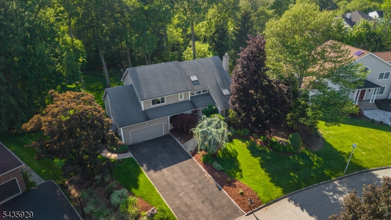 FABULOUS FLORHAM PARK 5 BED/3.1 BATH HOME ON PARK-LIKE PROPERTY IS PRIVATE OASIS YET CLOSE TO EVERYTHING! Welcome to Columbia Manor, a well-kept neighborhood with cul-de-sacs, sidewalks & lush lawns tucked between the conveniences of Columbia Turnpike & the town recreation center. Amazing curb appeal with gorgeous perennial beds & statement trees. Backyard is green, flat & private, with stone fire pit & incredible Trex deck built for entertaining w/ natural gas grill & outdoor bar & heater, included in sale! Inside, you'll be drawn to the vaulted ceilings w/ skylights, tall windows, red oak hardwood floors & expansive rooms that offer great versatility. Front-to-back Family/Living Room boasts stone fireplace ready for cozy nights & opens to Eat-in Kitchen, both with sliders to back deck. Kitchen fully renovated in 2019 w/ custom cabinetry, quartz countertops, SS appliances like professional gas cooktop & double wall oven, microwave drawer, beverage bar w/ under-counter fridge & large center island with great views of the backyard. 1st Level also features a Bedroom, Full Bath, Powder Room & access to attached 2-car Garage with vaulted ceilings. Upstairs includes 3 more Bedrooms + vast Primary Suite w/ vaulted ceiling & sitting area w/ private balcony overlooking backyard. Just imagine unwinding here after a long day! Upgraded Ensuite Bath features skylight, Walk-in Closet, double vanity & walk-in shower. Lower Level has huge Rec/Game Room, Laundry, workbench & lots of storage.