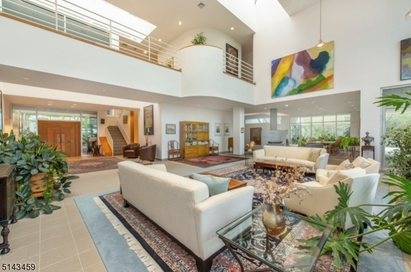 Luxurious CONT interior in this spacious 10,233 sq ft. home with soaring ceilings, walls of glass allowing for sun-soaked rooms, soapstone WDBRN STV, SGDS to BALCS from nearly every richly appointed room. Endless amounts of peace and privacy on over 2 acres of manicured lush grounds wait at the end of a private road. The home accommodates one-floor living with one of 2 MBR suites on the 1st level. The impressive 2nd-floor great room is an entertainer's dream and the 3-story expansive space allows for endless possibilities. The lower level boasts Olympic size length lap pool with a cabana, kitchenette, and full gym. Unique features include a 3 car garage with an electric charging station, whole house generator, and upgraded solar system. Award-winning SCHL SYS. Mins from Manhattan.