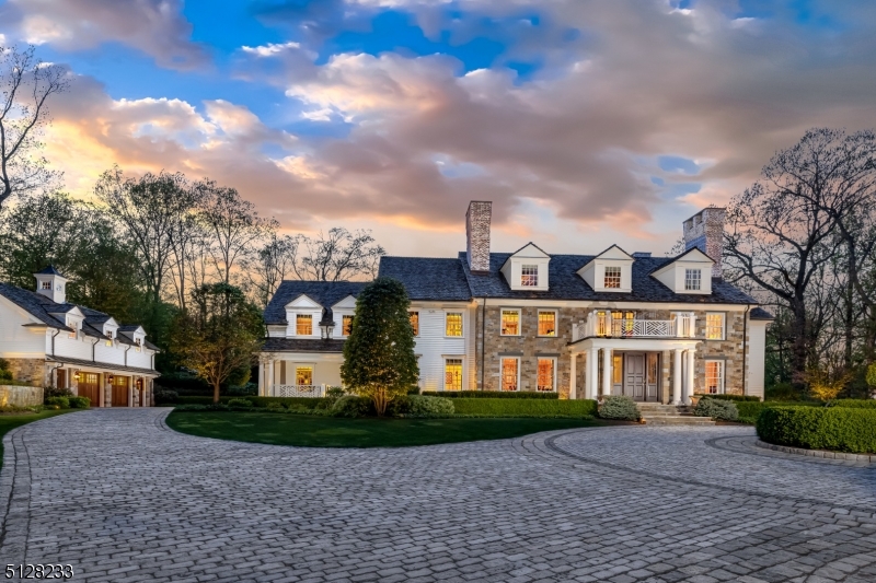 A full redesign completed in 2021 created this exceptional Bernardsville compound which includes the main home plus pool and carriage houses, offering several multi-generational living possibilities. The soaring foyer opens to the gallery above, and all the way to the rear of the home inviting an easy flow to the formal living and dining rooms. The kitchen is a feast for the eyes with, top of line appliances and custom cabinetry. The 3 walls of windows in the library truly bring the outdoors in. The primary suite with its vaulted ceiling, stunning sitting room, marble fireplace and bath is on the second floor. The gym, billiard room, bedroom/office, full bath, media room, utilities and storage are all located on the lower level. The amazing pool house opens to the patio area so you can easily enjoy the full gourmet kitchen and living room with its gas fireplace. The elevator takes you to the lower-level game room. The carriage house one-bedroom apartment is located over 2-oversized garage bays and enjoys the same superior level of finishing found throughout the home and grounds. The pool complex includes a large salt-water pool, waterfall and spa, travertine marble patio and pathways and full outdoor kitchen. Sampling of highlights: 5 gas fireplaces, extensive millwork, Clive Christian cabinetry, Calcutta Gold marble, Control 4 security, lighting and sound system, water filtration, architectural windows, hardwood floors, NanaWall, radiant heated walkways and courtyard.