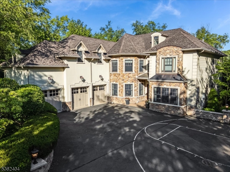 Discover this spacious custom colonial nestled in the sought-after Hartshorn section, offering 5 bedrooms including a first-floor in-law suite and 6 baths. A circular driveway leads to the first floor 3-car garage and a beautifully landscaped backyard with a park-like setting. Enter to a two-story great room featuring a gas fireplace w/custom built-ins. The gourmet chef's kitchen is the heart of the home, complete w/ large center island, high ceilings w/ beam detail, granite countertops, stainless steel appliances, walk-in pantry, butler's pantry and breakfast area that flows into a den with a fireplace. The main level includes a formal dining room with fireplace, elegant living room/office with built-ins, and in-law suite with private bath. Upstairs, the primary suite offers a sitting area, fireplace, spa-like bath, and three custom walk-in closets. Three additional bedrooms all with ensuites and a convenient second floor laundry complete the second level. The walk-out lower level features a massive rec room, new gym floor, wine cellar, guest room/office, full bath, new spa room with sauna, new carpet and new ceiling. Freshly painted interior and newer whole house generator. Enjoy resort-style outdoor living with a newly fully fenced backyard featuring an outdoor kitchen, built-in grill, fireplace, playset, new exterior light fixtures and brand new stairs leading from back and side of the house. Truly an exceptional home that combines luxury, function, and timeless design.